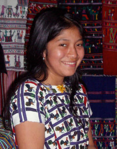 Nebaj girl in 2007. Photo by Flickr user Lon&Queta, who note: "Her huipil is from Santiago Atitlán. New trend of wearing "foreign" huipiles (from other parts of Guatemala). Used to be that no woman would wear anything not from her own town!"